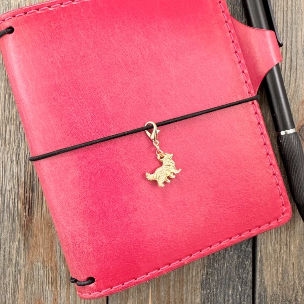 1 Handmade vintage gold-tone Collie dog charm with lobster clasp on a pink leather journal.