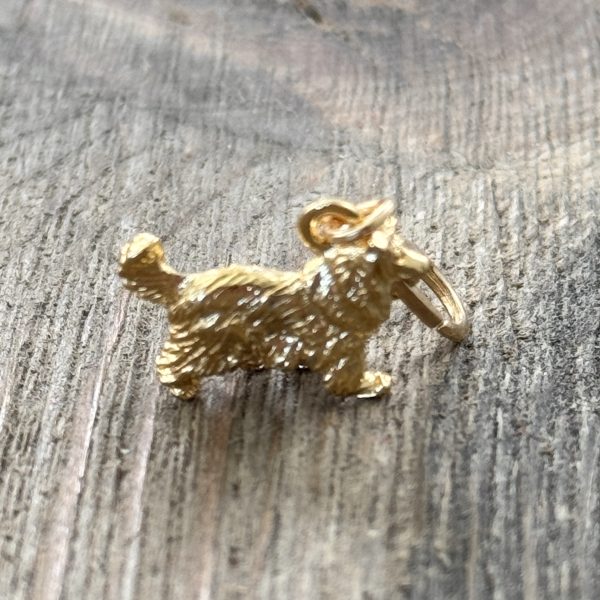 1 Handmade vintage gold-tone Collie dog charm with lobster clasp on a wood background.