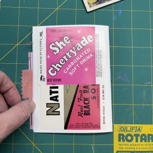 The back of a mini junk journal, decorated with vintage pink soda labels