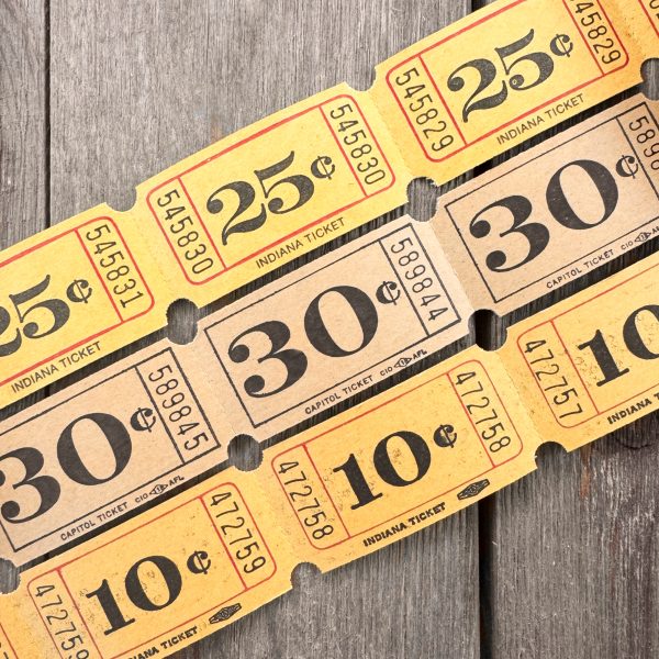 Three rows of vintage yellow carnival tickets