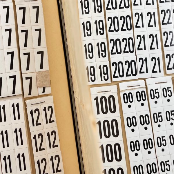 An open vintage price sticker book showing various black and white pricing stickers