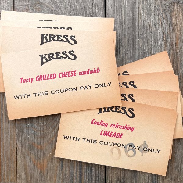 2 Piles of aged vintage Kress coupons - one is for a Grilled Cheese sandwich and the other is for a Limeade soda
