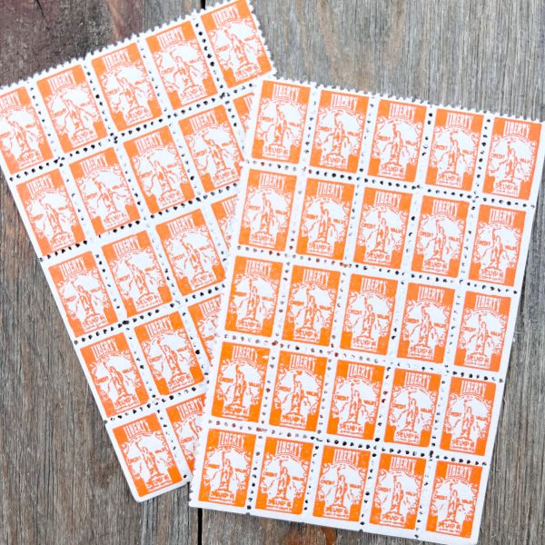 Two sheets of 25 vintage orange & white Liberty Saving stamps, each featuring an illustration of the Statue of Liberty