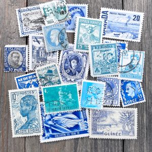 Twenty random vintage and antique monochromatic postage stamps in shades of aqua and blue