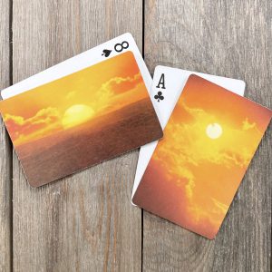 Four assorted playing cards featuring sunsets