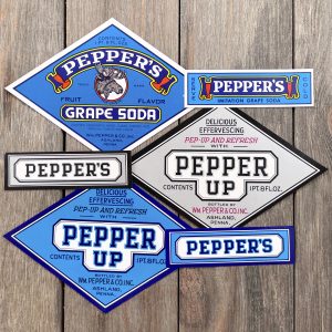 Six different vintage Pepper’s Soda labels in shades of blue and silver