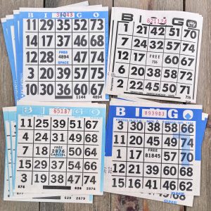 Sixteen vintage blue and white paper bingo card sheets in four different styles