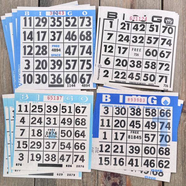 Sixteen vintage blue and white paper bingo card sheets in four different styles