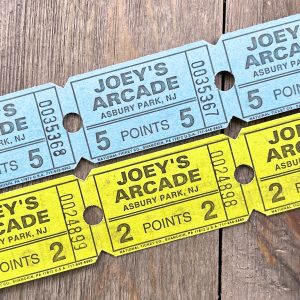 Two rows of vintage Joey’s Arcade tickets in blue and yellow.