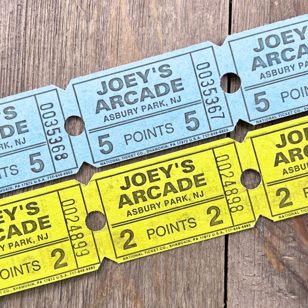 Two rows of vintage Joey’s Arcade tickets in blue and yellow.