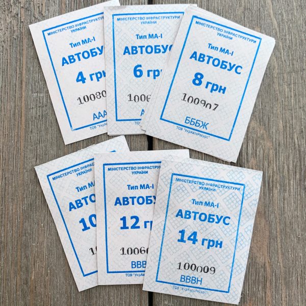 Six piles of vintage blue and white Ukrainian bus tickets