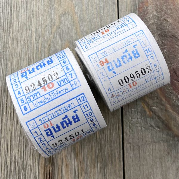 Two rolls of vintage blue and white bus tickets from Thailand