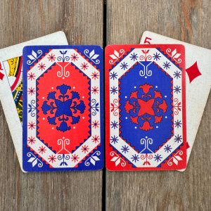 Four assorted vintage red, white, and blue patterned playing cards