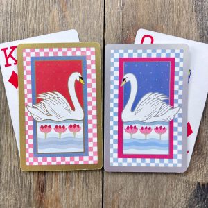 Four assorted vintage red, white, and blue swan playing cards from the 1980s