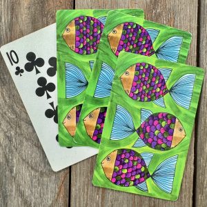 Four vintage playing cards featuring colorful cartoon fish