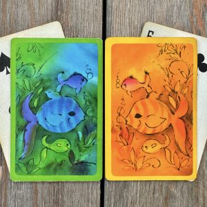 Four assorted vintage playing cards featuring blue and orange fish