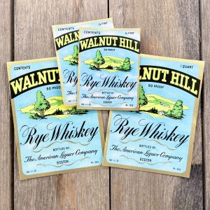 Four assorted vintage Walnut Hill Whiskey labels in two sizes, each featuring an illustration of a grassy hill