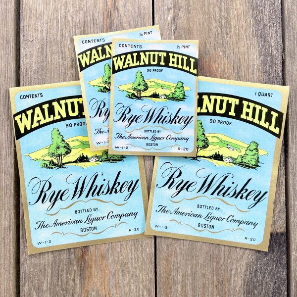 Four assorted vintage Walnut Hill Whiskey labels in two sizes, each featuring an illustration of a grassy hill