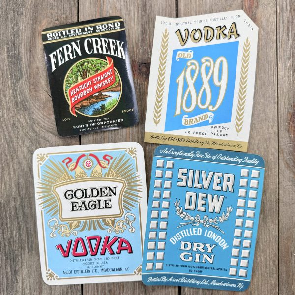 Four different vintage cool-tone liquor labels from the 1940s