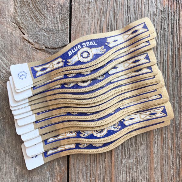 Twenty vintage blue, gold, and white Blue Seal cigar bands